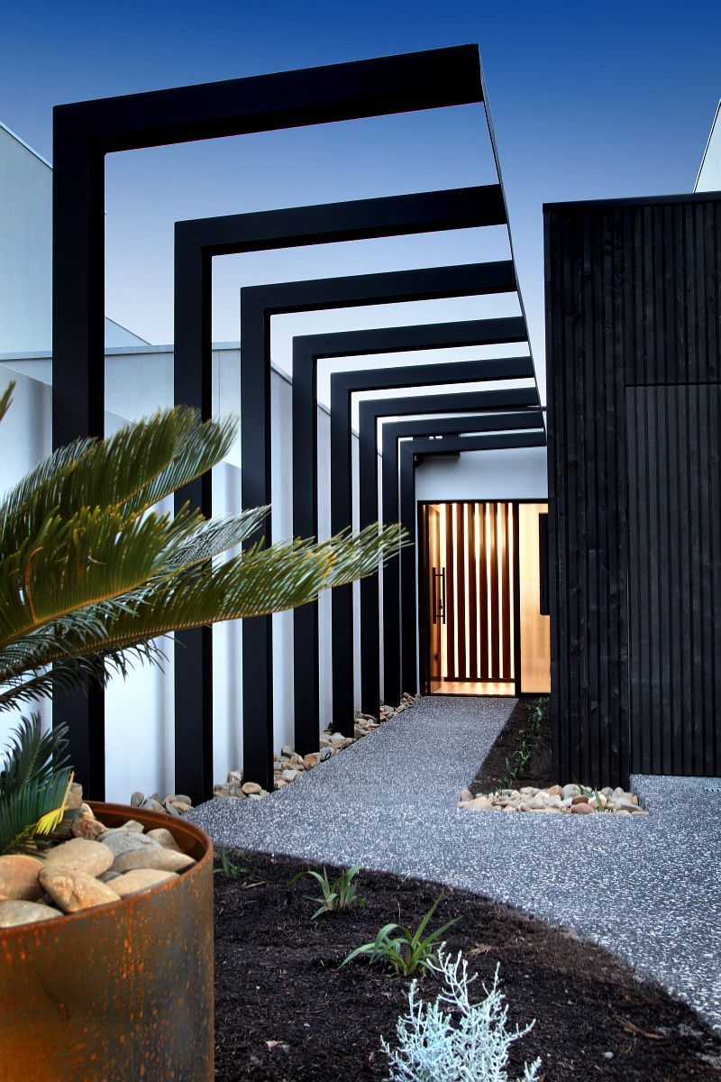 A Patio With A Table And Chairs In Front Of A House With A Pool — KM Custom Homes In Mount Eliza, VIC