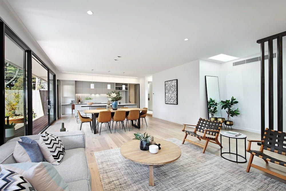 A Living Room With A Couch , Chair , Table And Rug — KM Custom Homes In Mount Eliza, VIC