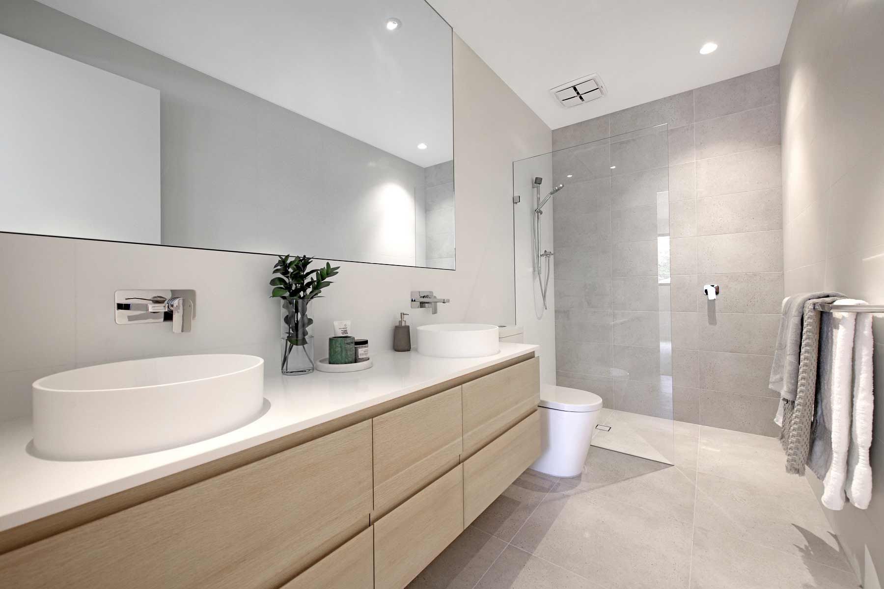 A Bathroom With Two Sinks, A Toilet, And A Walk In Shower — KM Custom Homes In Mount Martha, VIC
