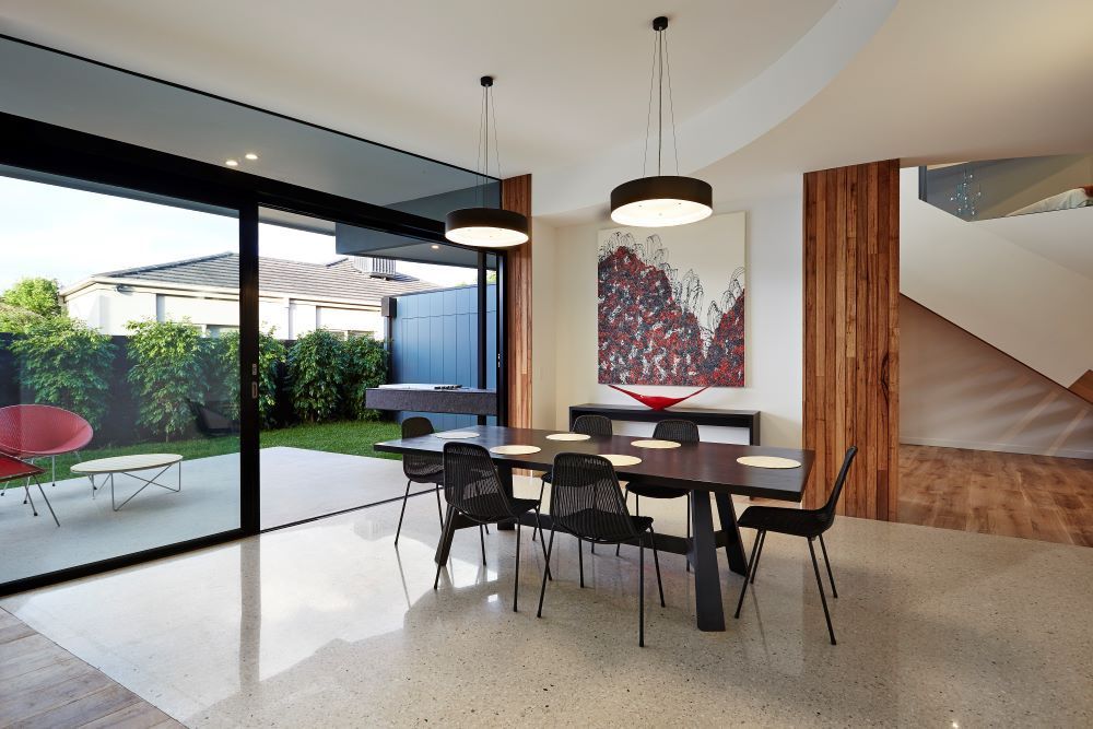 A Dining Room With a Table and Chairs and a Painting on the Wall — KM Custom Homes In Mount Eliza, VIC