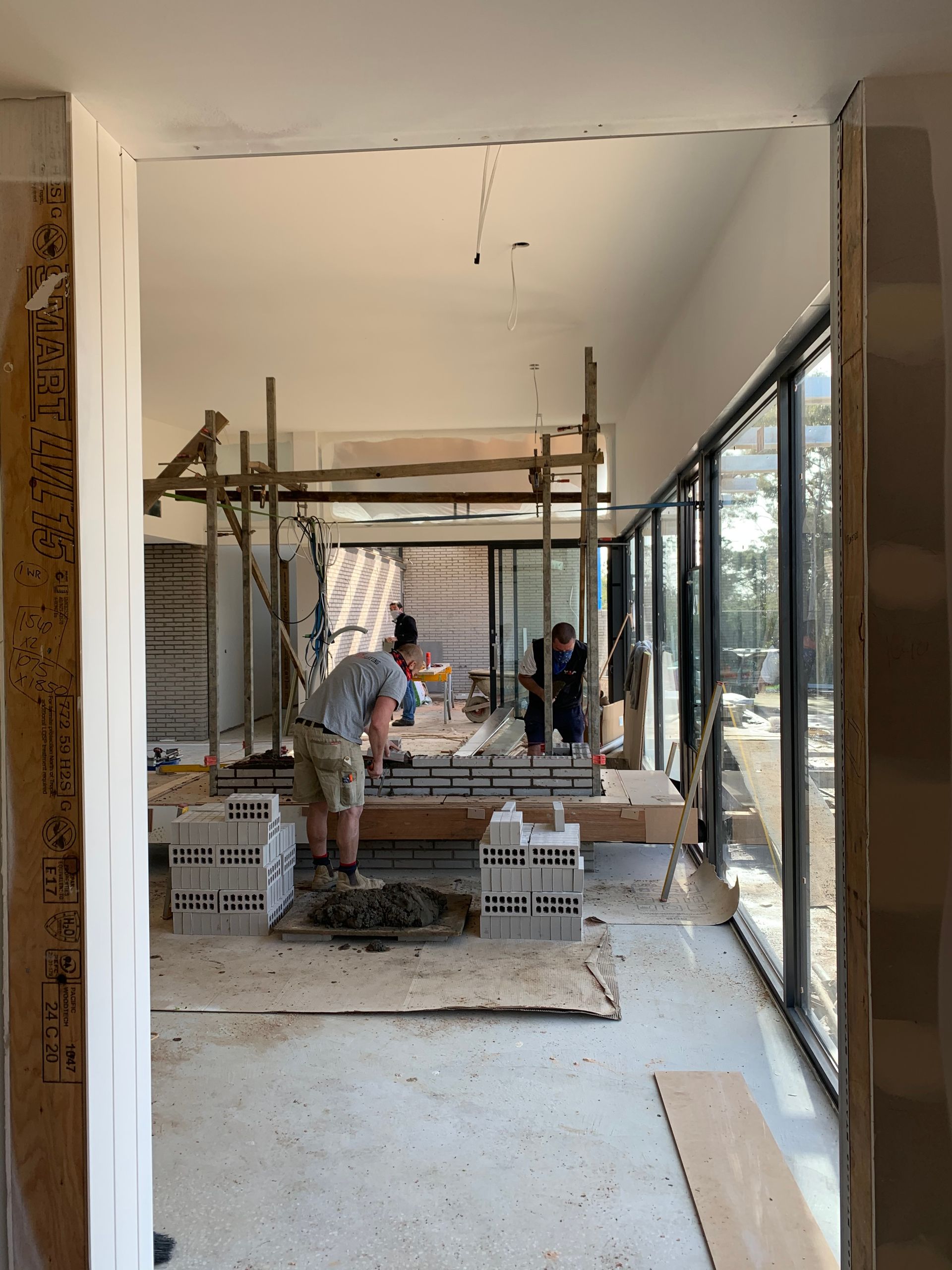A Man Is Standing In A Room With A Lot Of Windows — KM Custom Homes In Mount Eliza, VIC