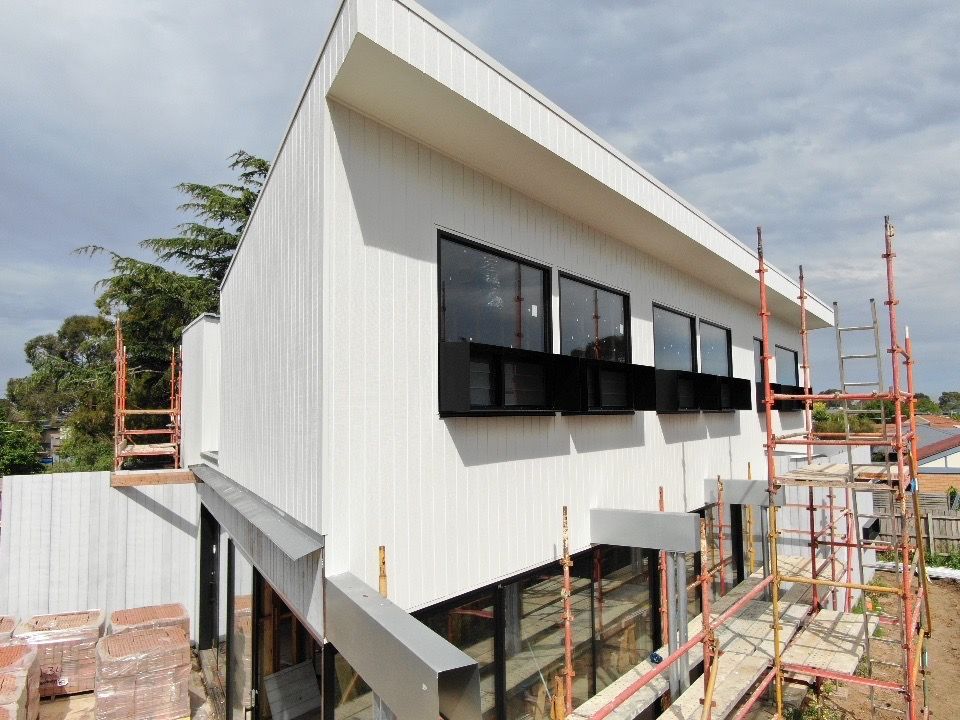 A Large White House Is Being Built With Scaffolding Around It — KM Custom Homes In Mount Eliza, VIC