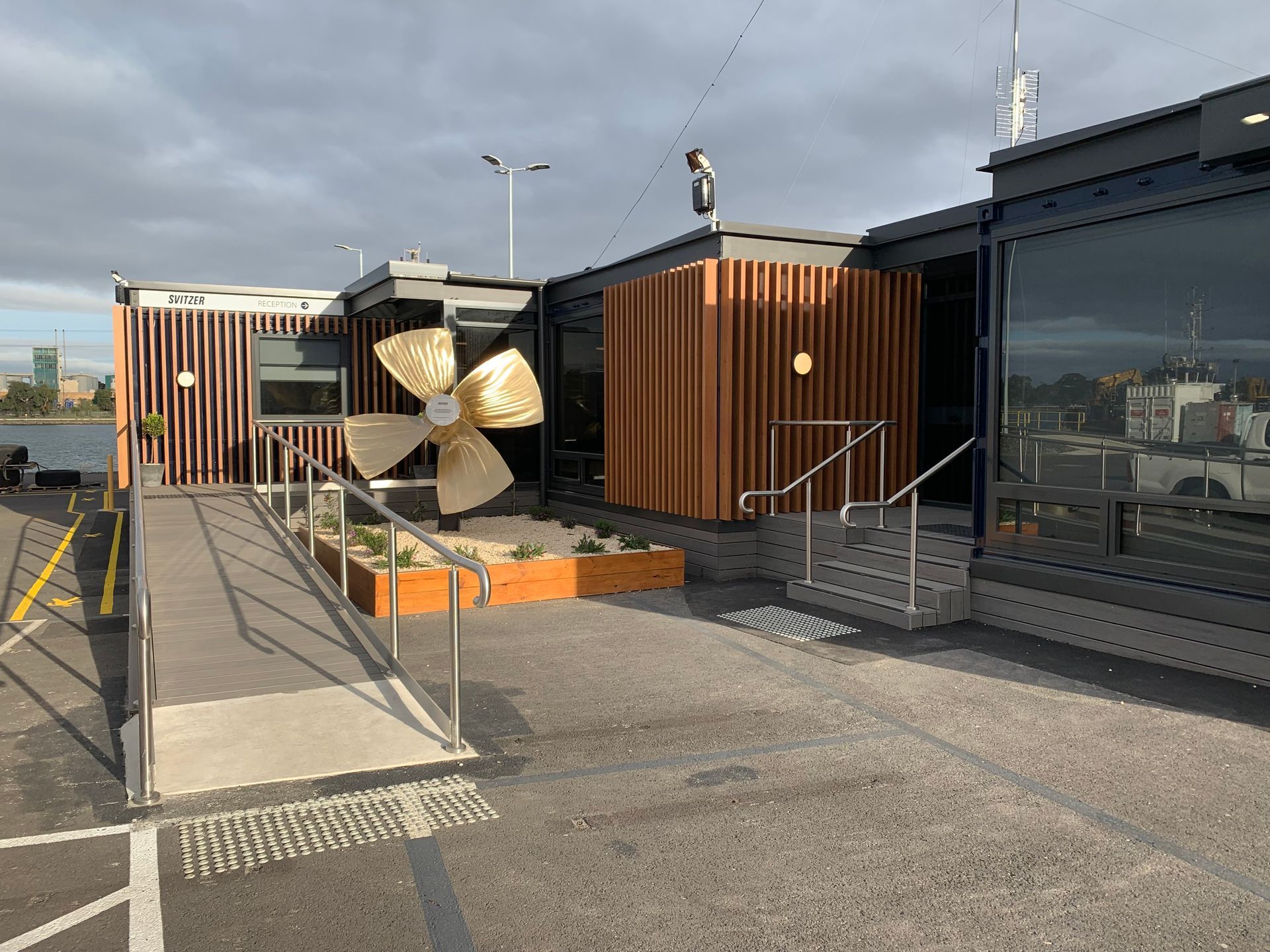 A Building With A Ramp And A Large Propeller In Front Of It — KM Custom Homes In Red Hill, VIC