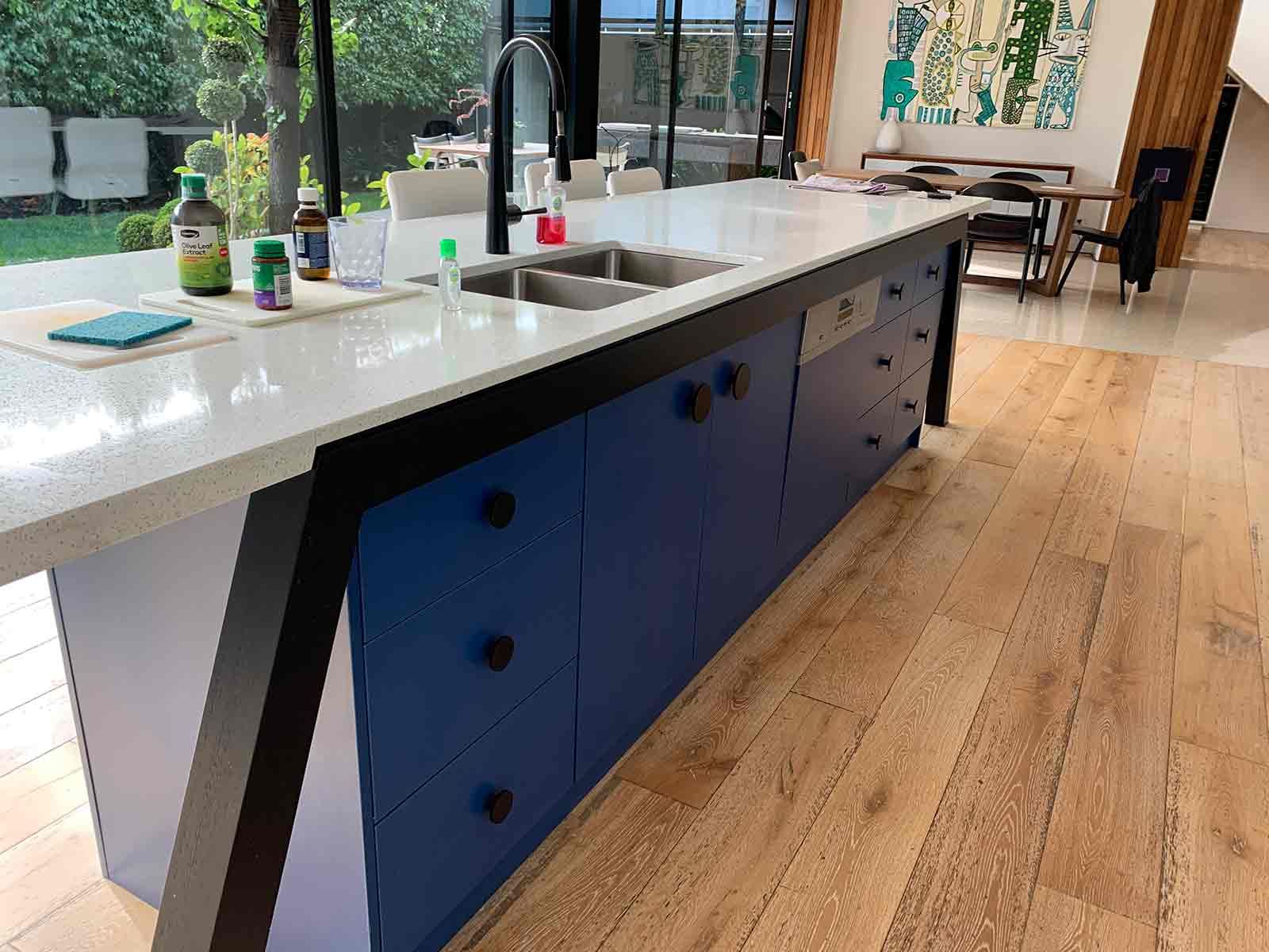 A Kitchen With Blue Cabinets , White Counter Tops , And A Sink — KM Custom Homes In Frankston South, VIC