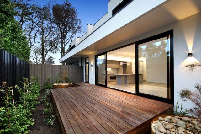 A Modern House With a Wooden Deck and Sliding Glass Doors — KM Custom Homes In Mount Eliza, VIC