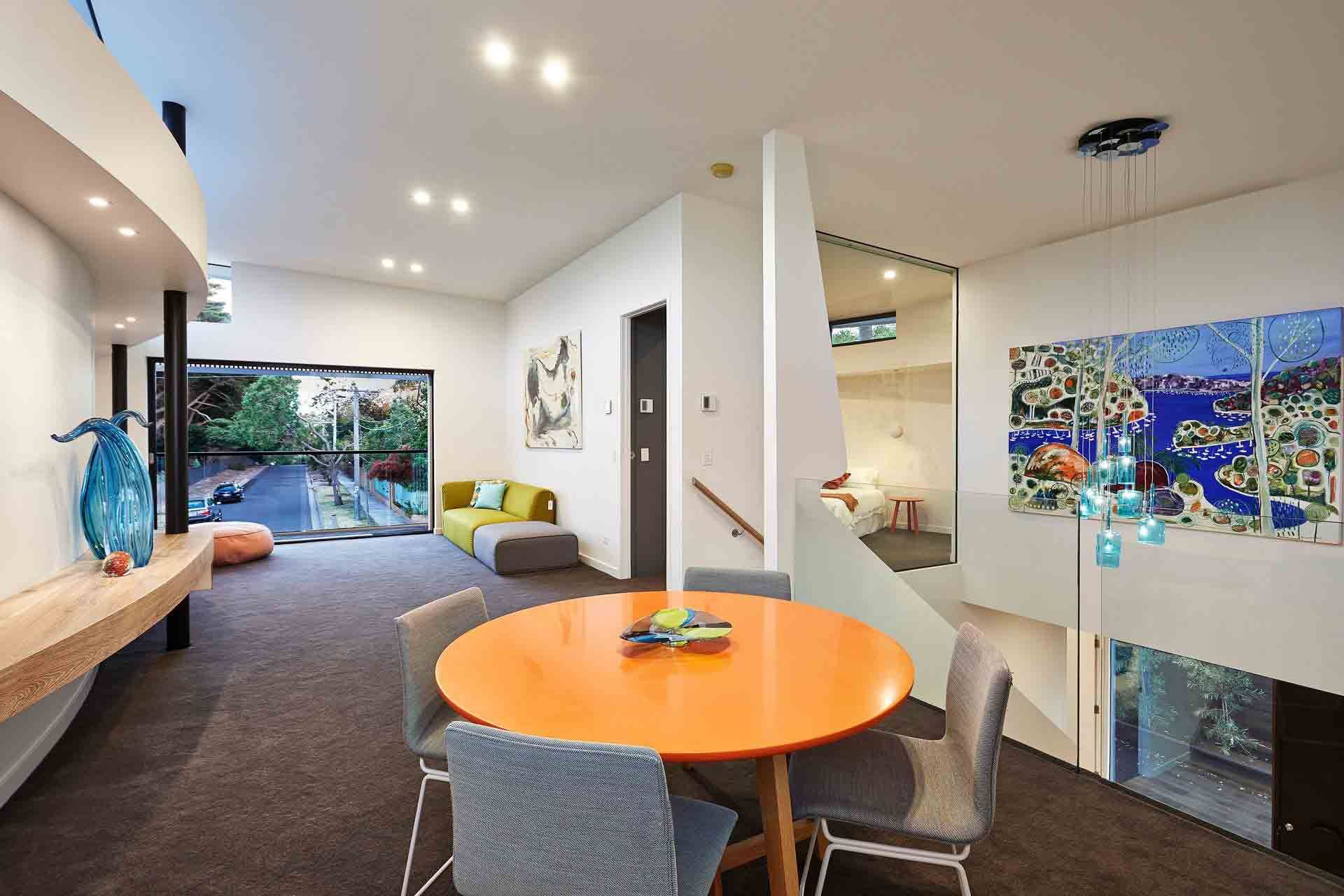 A Living Room With a Round Orange Table and Chairs — KM Custom Homes In Mount Eliza, VIC