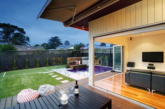 There is a Table With a Bottle of Wine on It in the Backyard of a House — KM Custom Homes In Mount Eliza, VIC