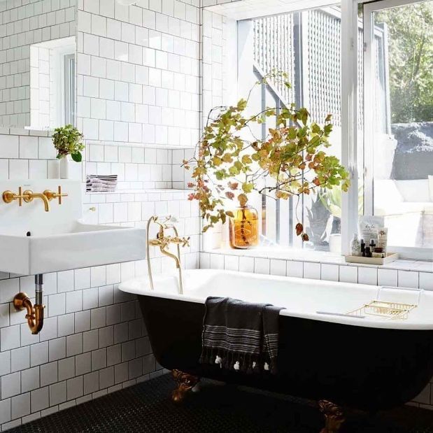 A Bathroom With a Black Tub a Sink and a Window — KM Custom Homes In Mount Eliza, VIC