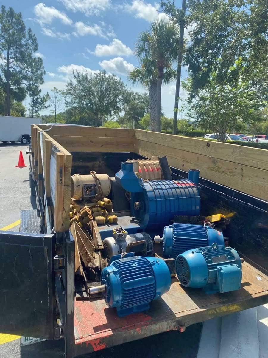 A trailer filled with blue motors is parked in a parking lot.