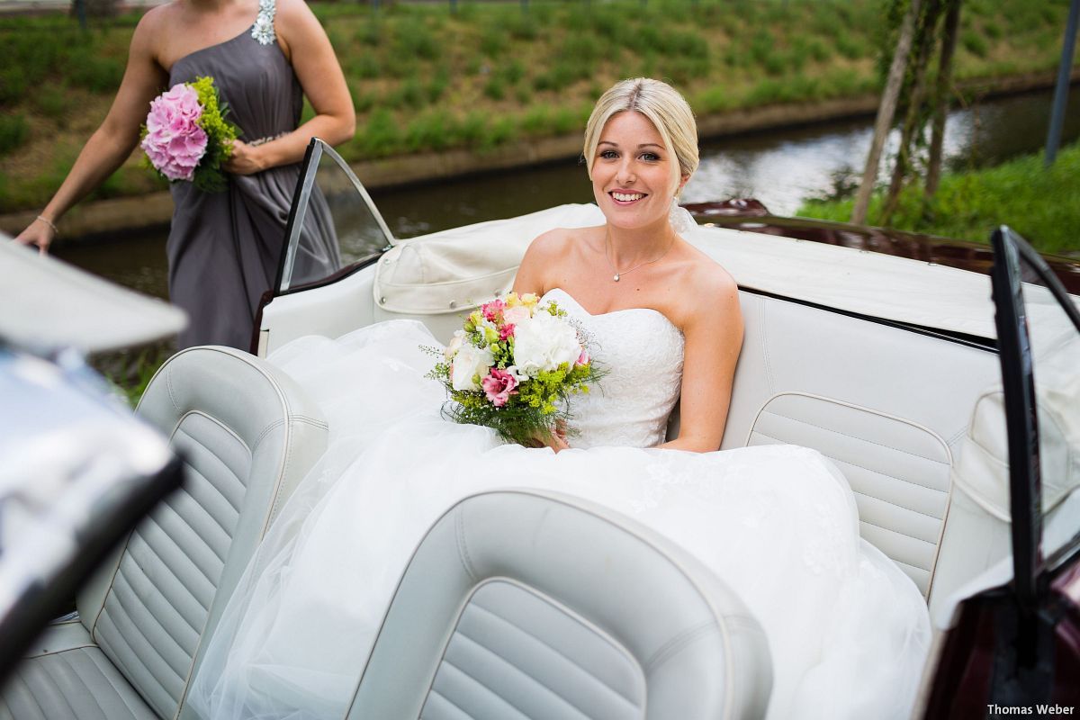 Eine Braut im Brautkleid sitzt auf dem Rücksitz eines Autos.