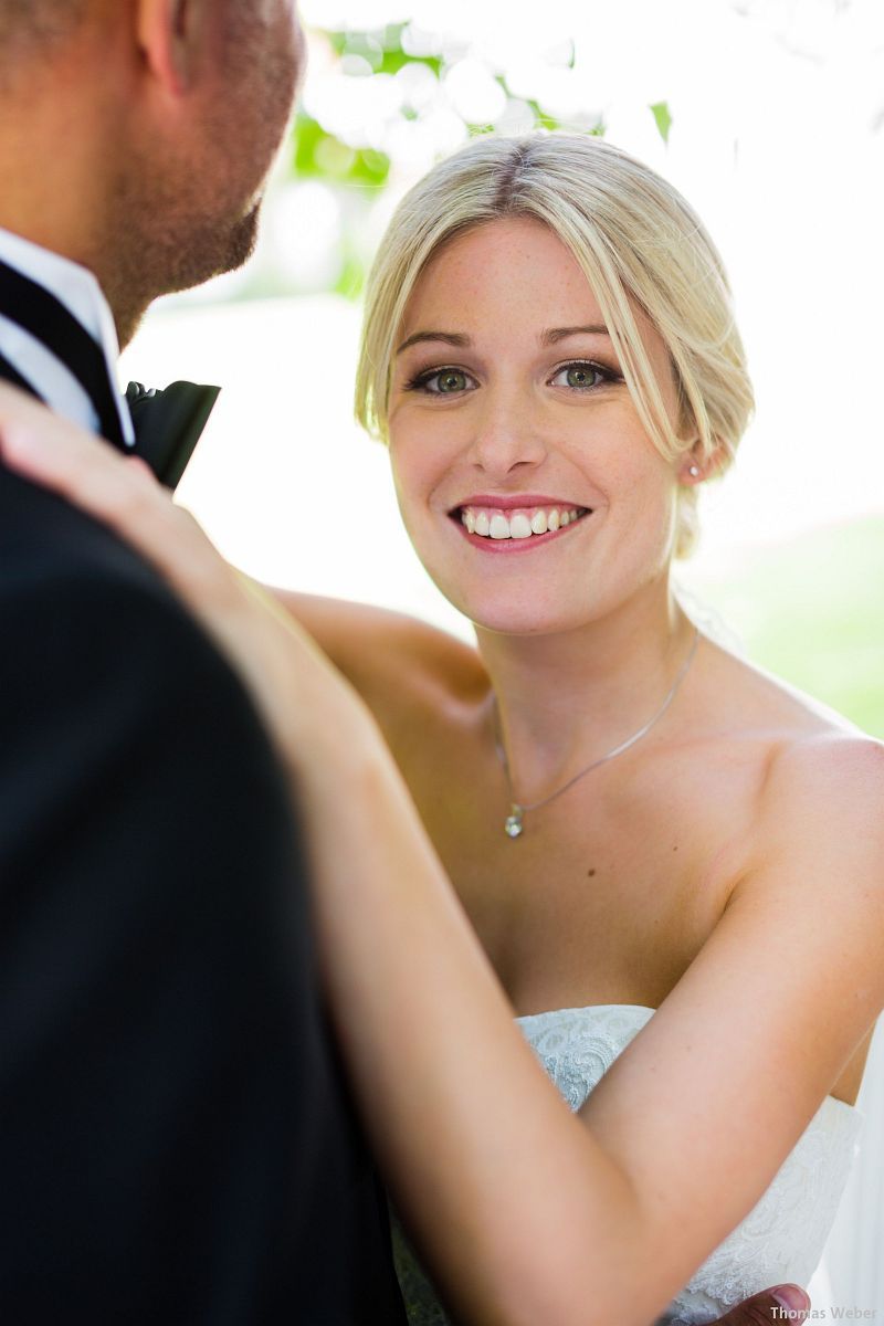 Eine Braut und ein Bräutigam posieren für ein Foto und die Braut lächelt