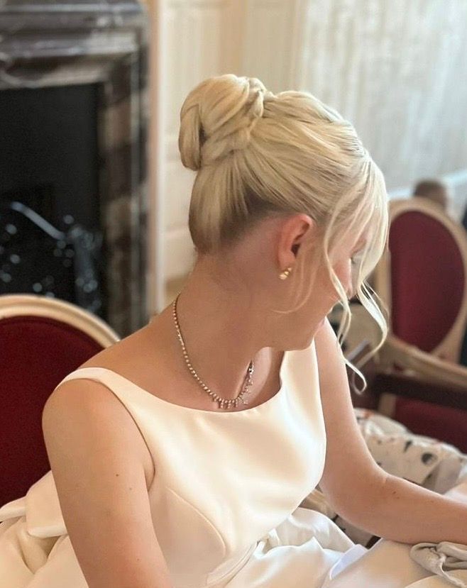 Eine Frau in einem weißen Kleid hat ihr Haar zu einem Dutt gebunden