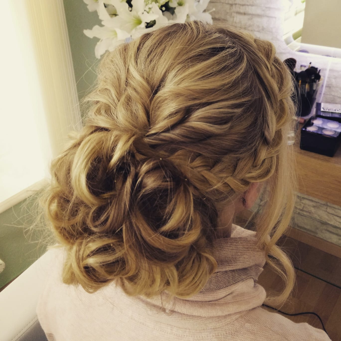 Eine Frau trägt ihr Haar in einer halb hochgesteckten, halb offenen Frisur