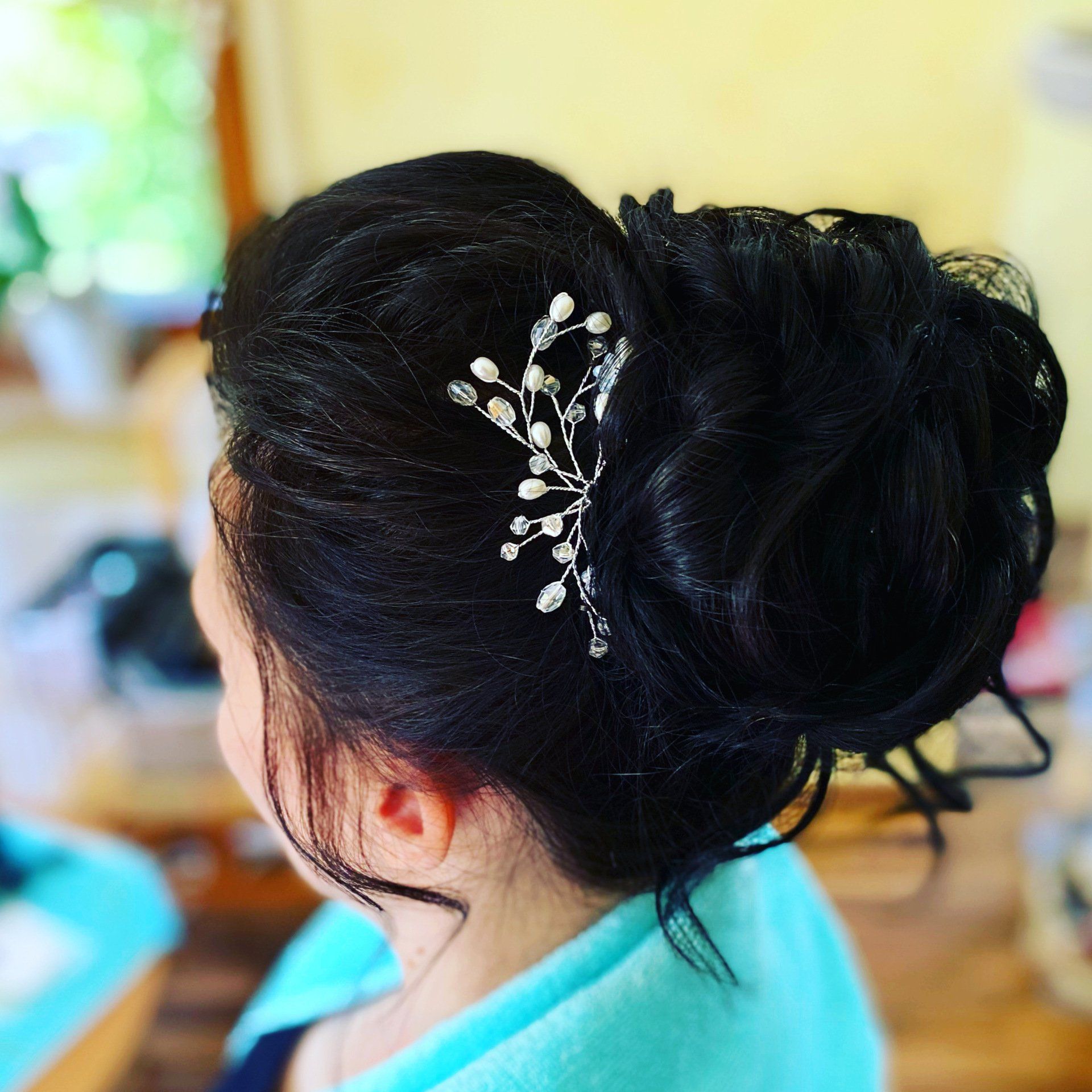 Eine Frau hat ihr Haar zu einem Dutt hochgesteckt, in dem sich ein Kamm befindet