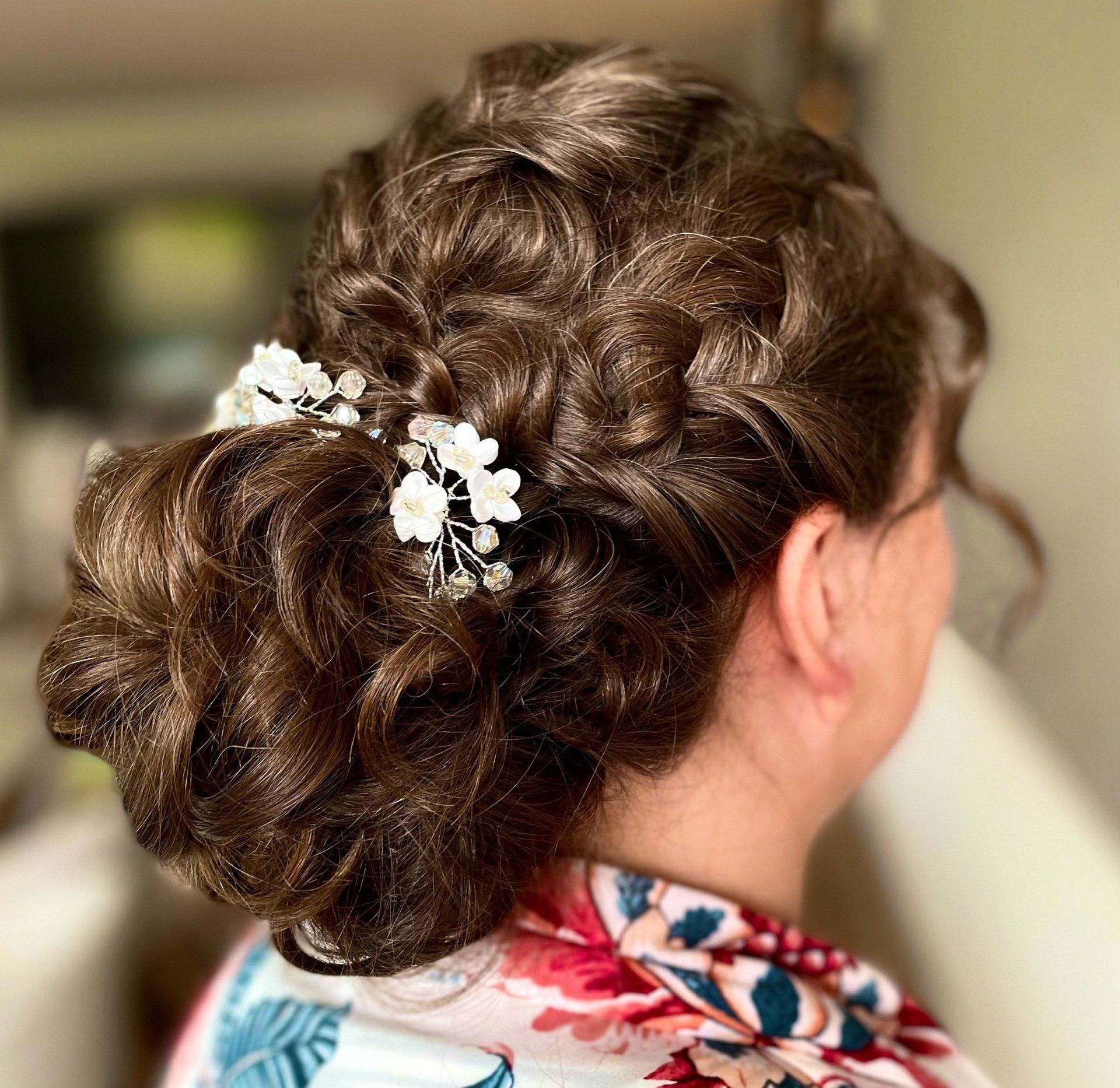 Eine Frau trägt ihr Haar zu einem Dutt mit Blumen darin.