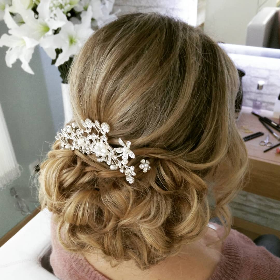 Eine Frau trägt ihr Haar zu einem Dutt hochgesteckt und hat eine Blume darin.