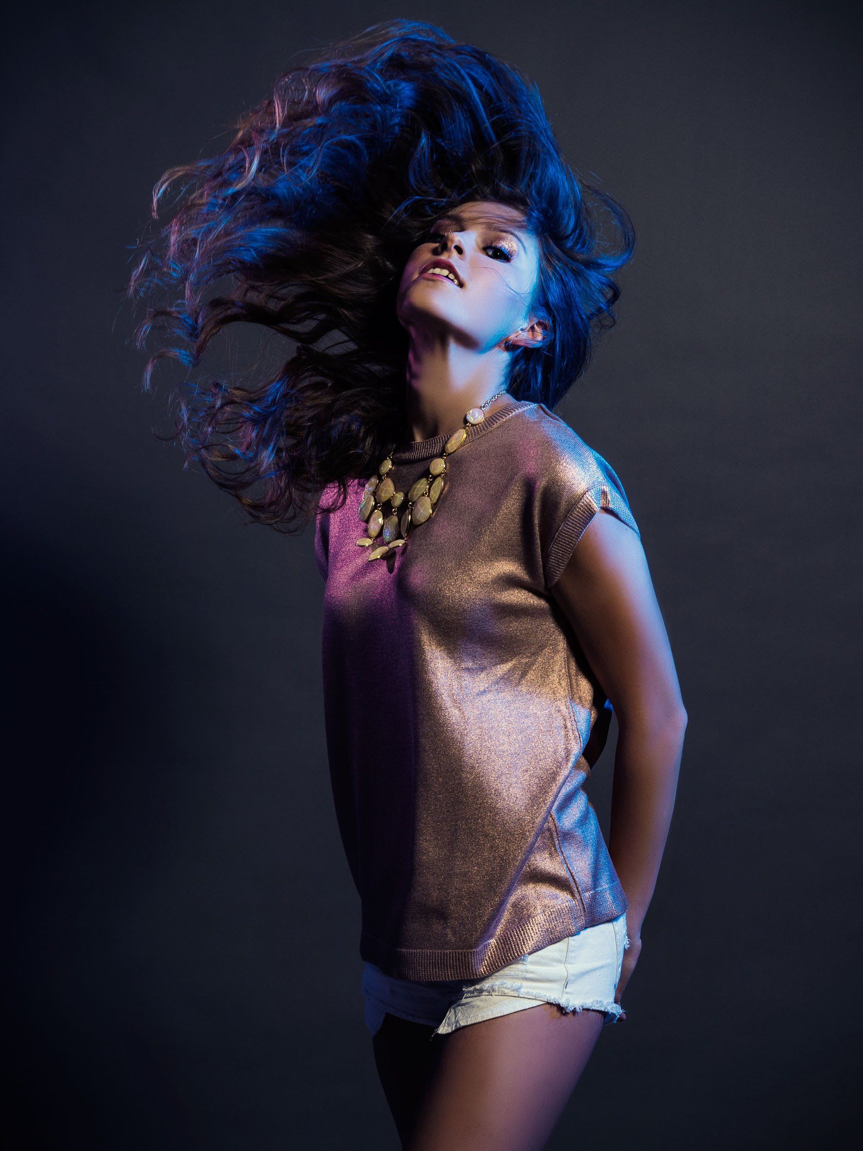 Eine Frau tanzt, während ihr Haar im Wind weht.