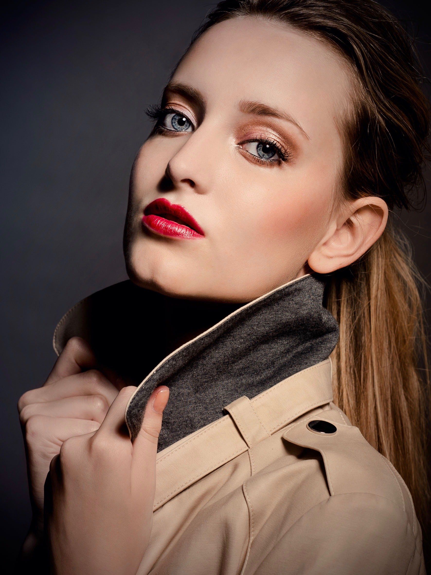 Eine Frau mit Trenchcoat und Schal um den Hals