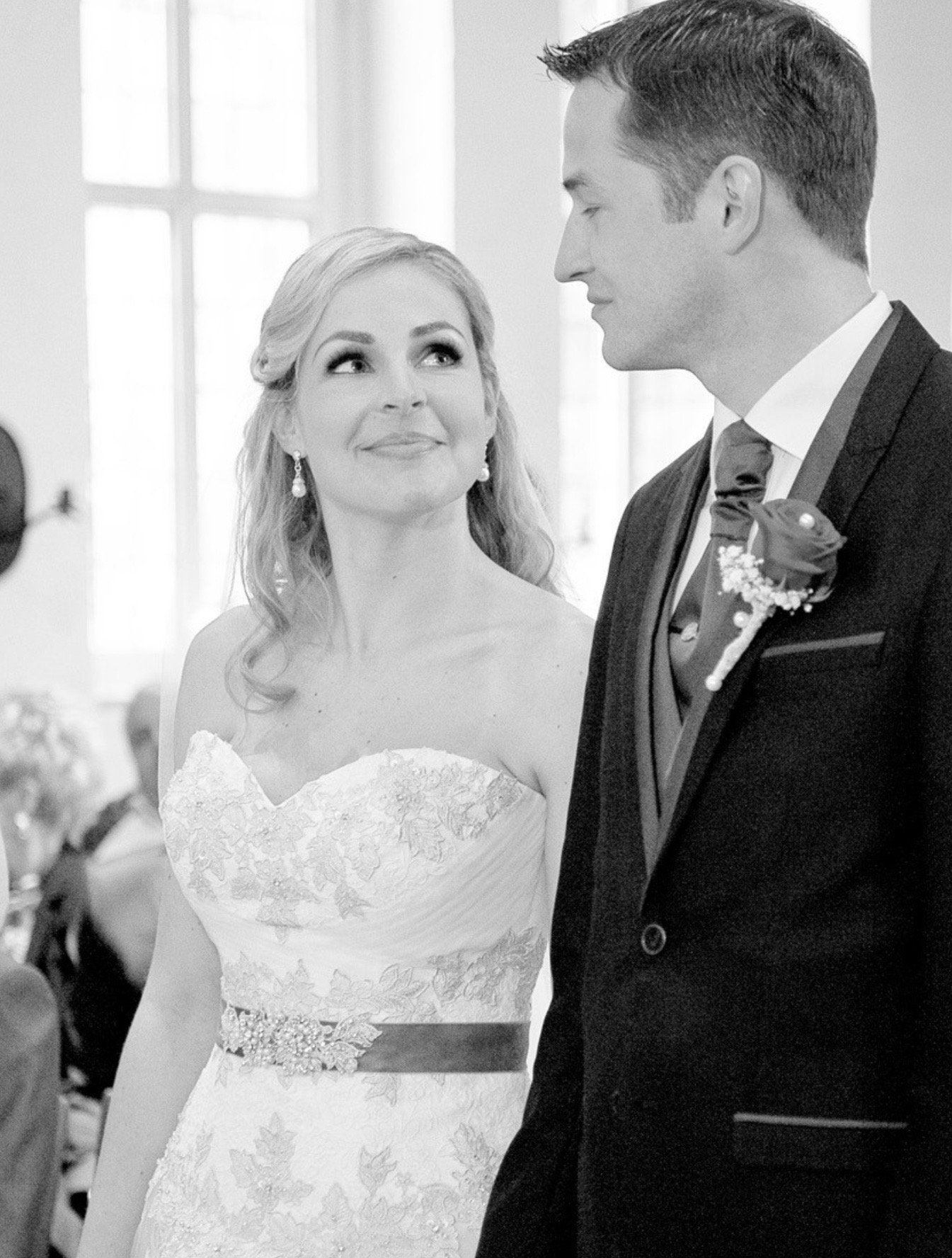 Ein Schwarzweißfoto einer Braut und eines Bräutigams, die Händchen halten.