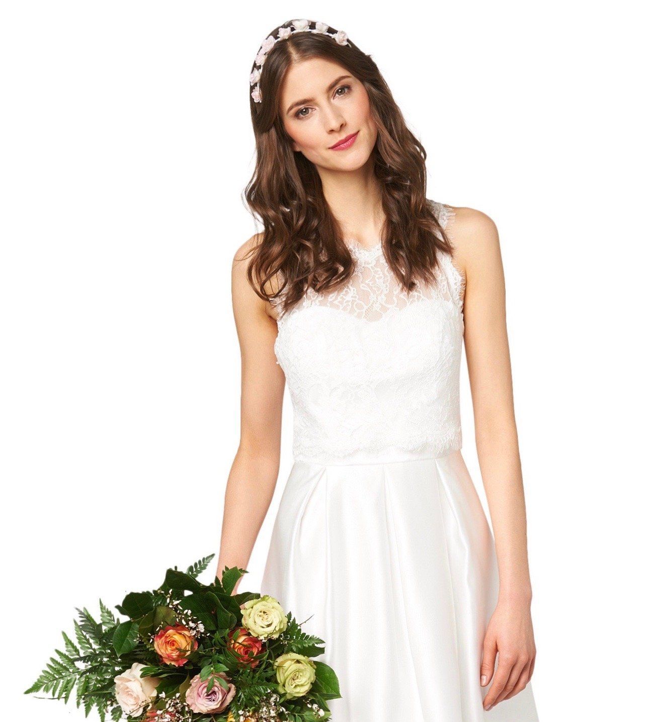 Eine Frau in einem Brautkleid hält einen Blumenstrauß.