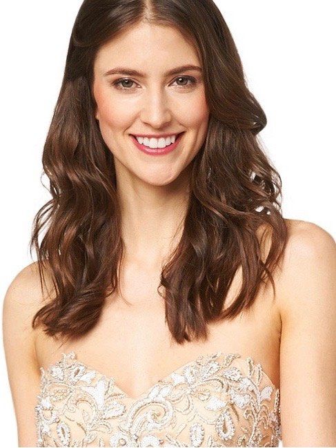 Eine Frau in einem trägerlosen Kleid lächelt in die Kamera