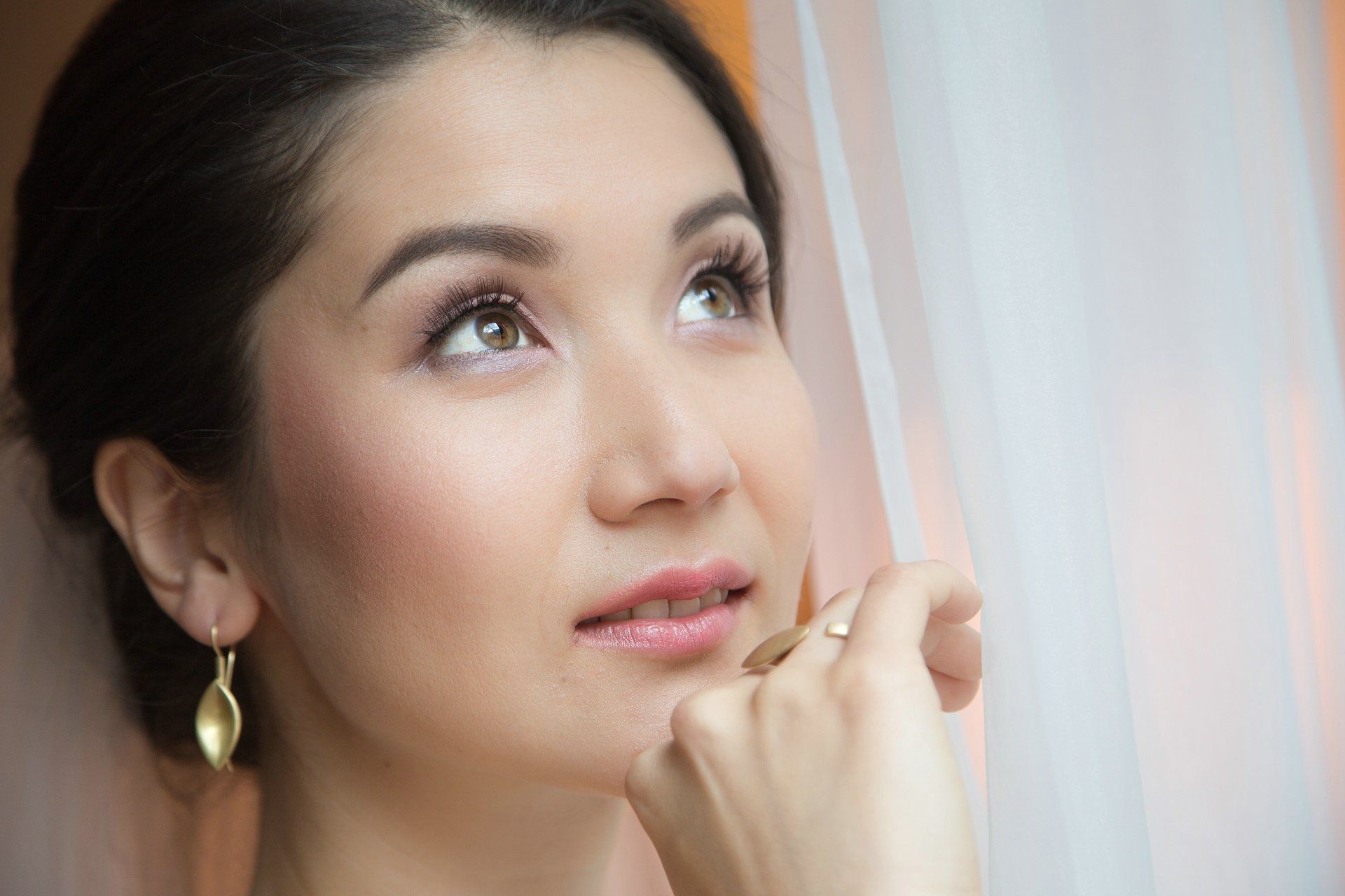 Eine Nahaufnahme des Gesichts einer Frau mit einem Ring am Finger.