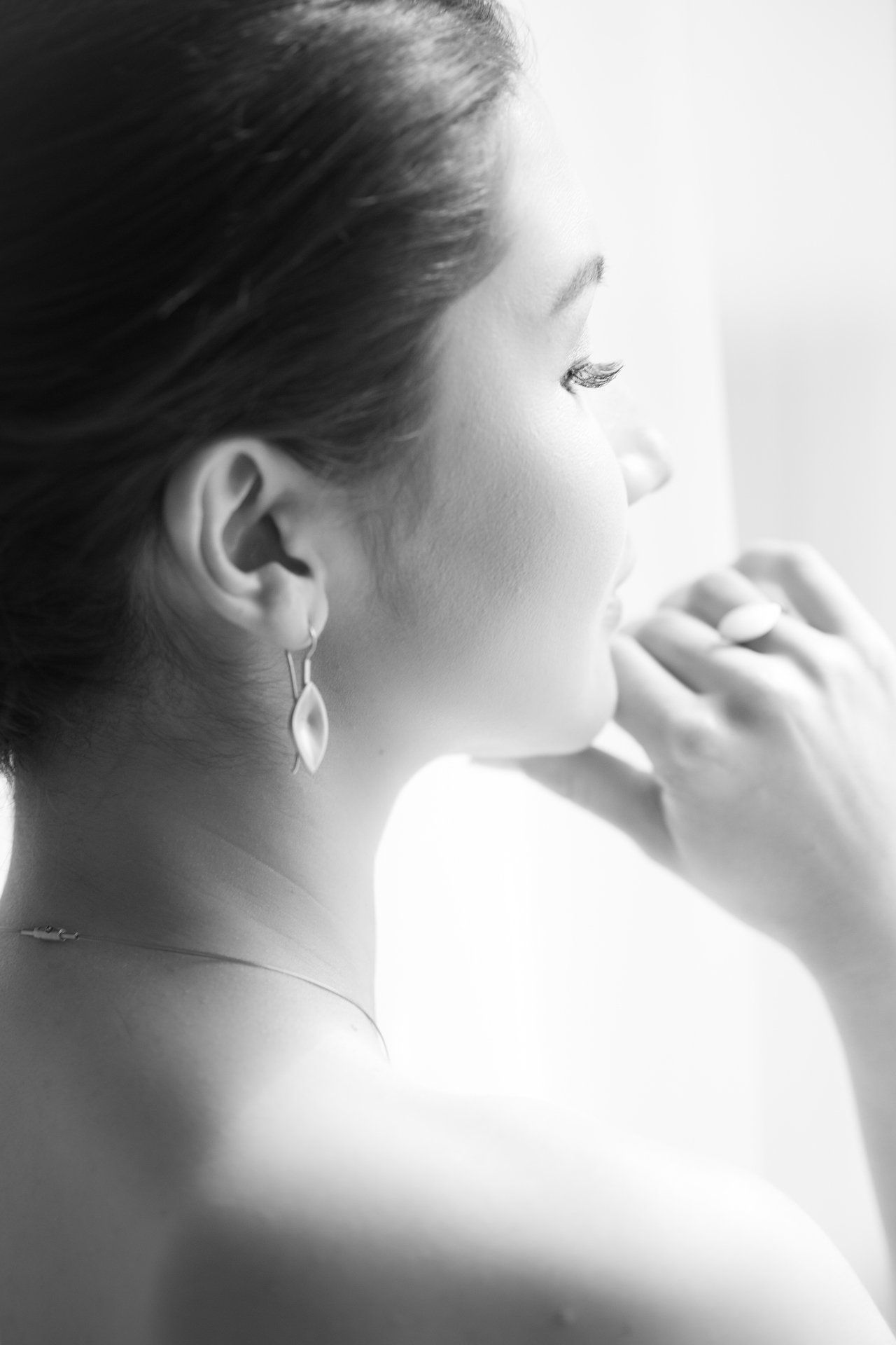 Ein Schwarzweißfoto einer Frau mit Ohrringen und einer Halskette.