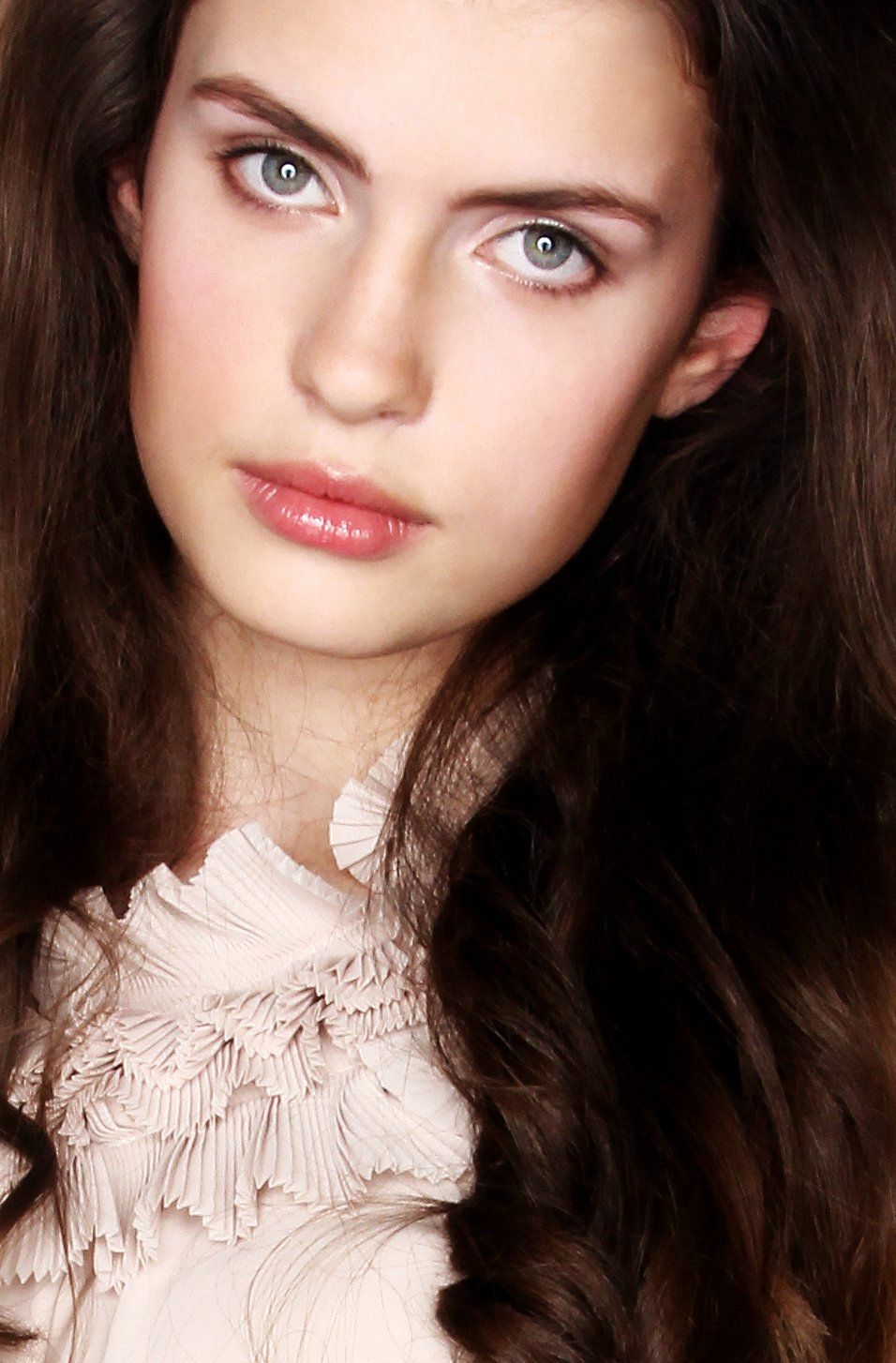 Eine Nahaufnahme des Gesichts einer Frau mit langen Haaren und blauen Augen