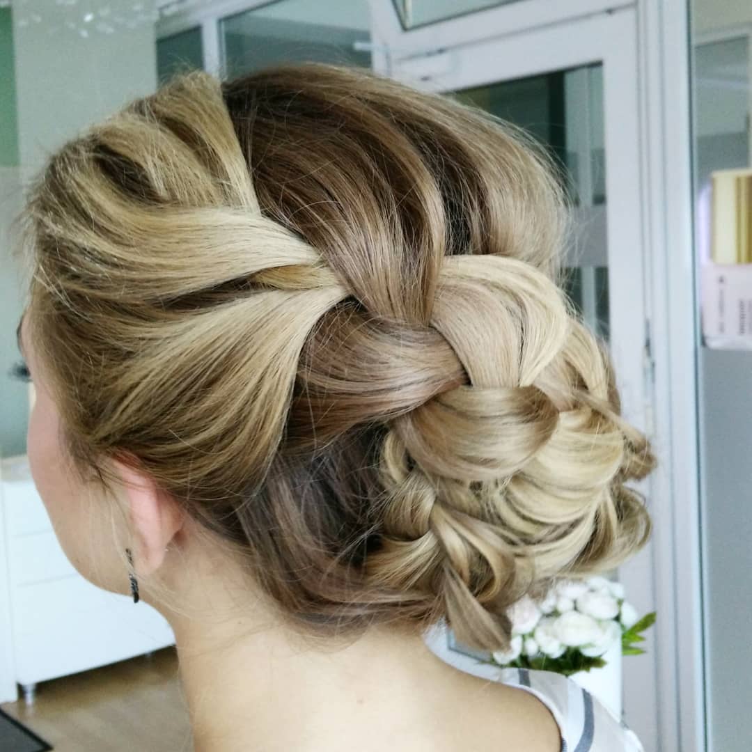 Eine Frau trägt ihr Haar zu einem geflochtenen Dutt.