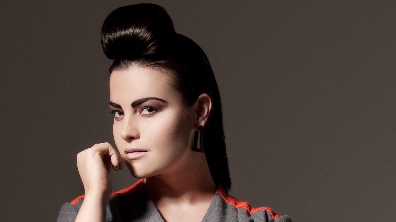 Eine Frau mit einem Dutt auf dem Kopf schaut in die Kamera