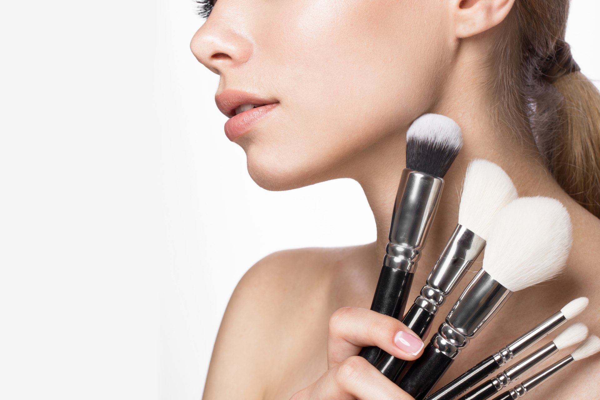 Eine Frau hält einen Stapel Make-up-Pinsel in ihren Händen.