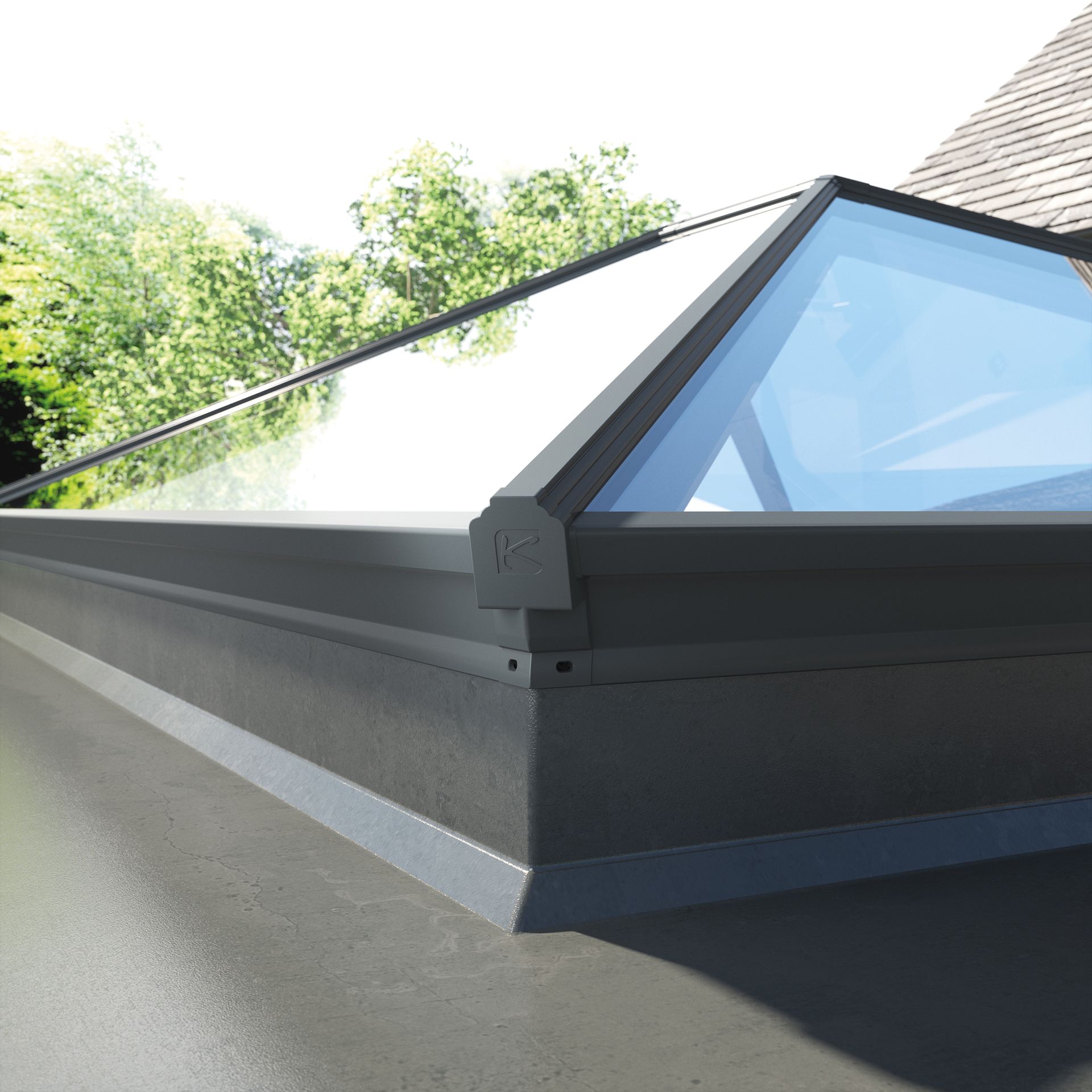 Skylight on a gray roof with a clear, angled glass pane and trees in the background.