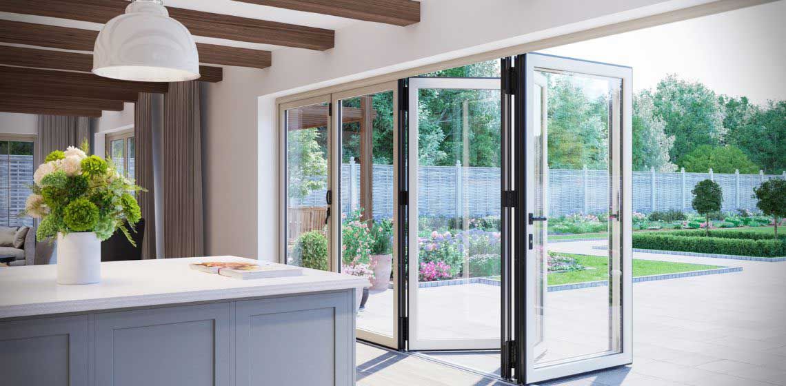 Open folding glass doors lead to a garden, revealing an outdoor view from inside.
