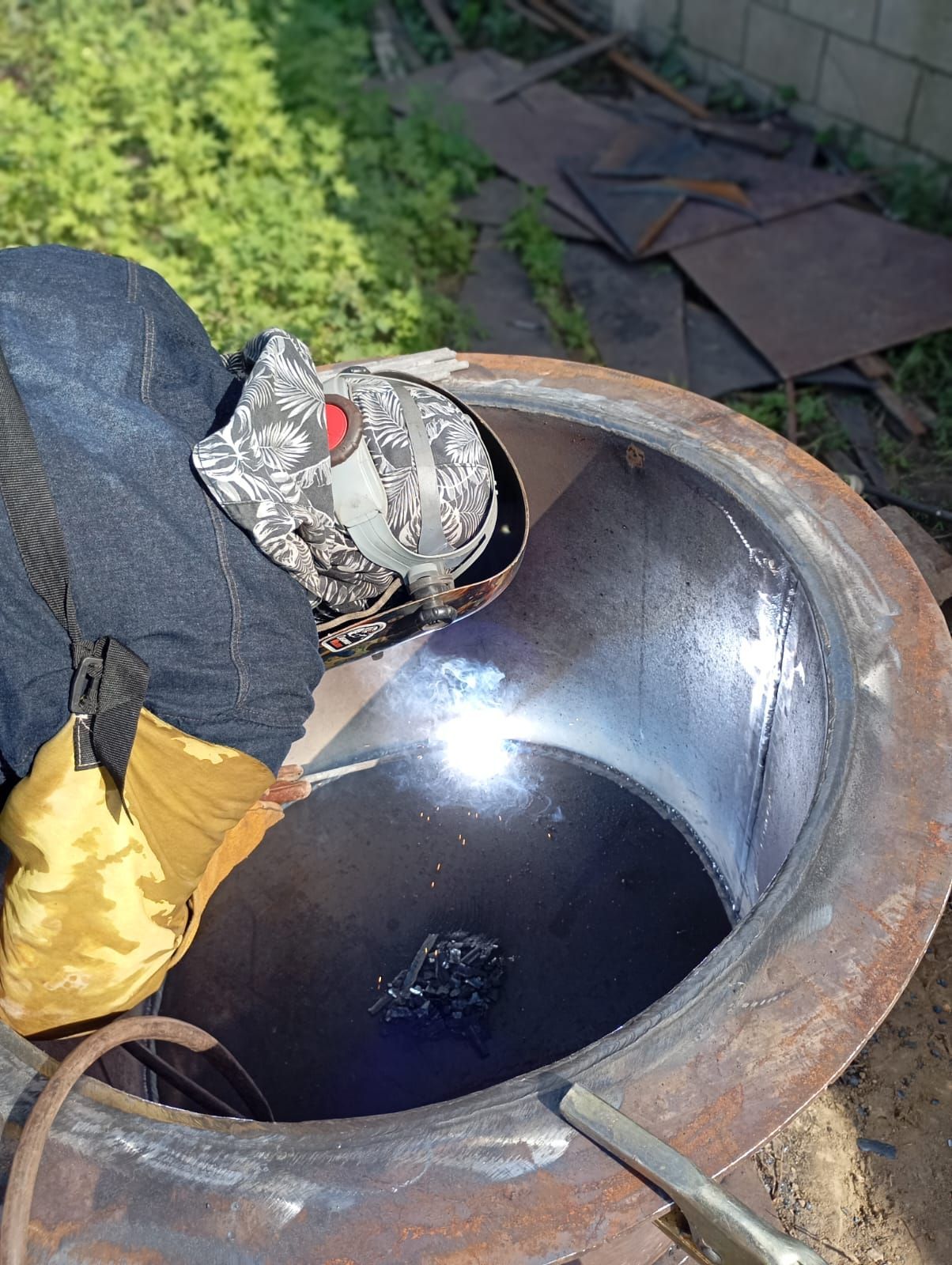 En un taller industrial, unos trabajadores inspeccionan tanques de acero inoxidable y un gran cilindro metálico.