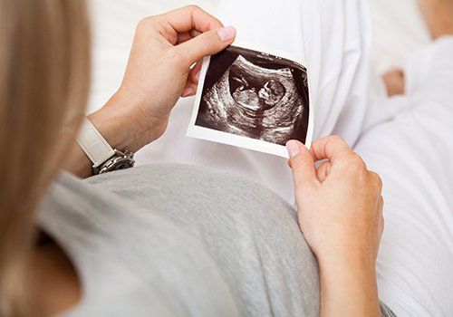 donna incinta che guarda un'ecografia