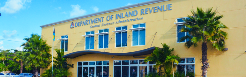 The department of inland revenue building is surrounded by palm trees.