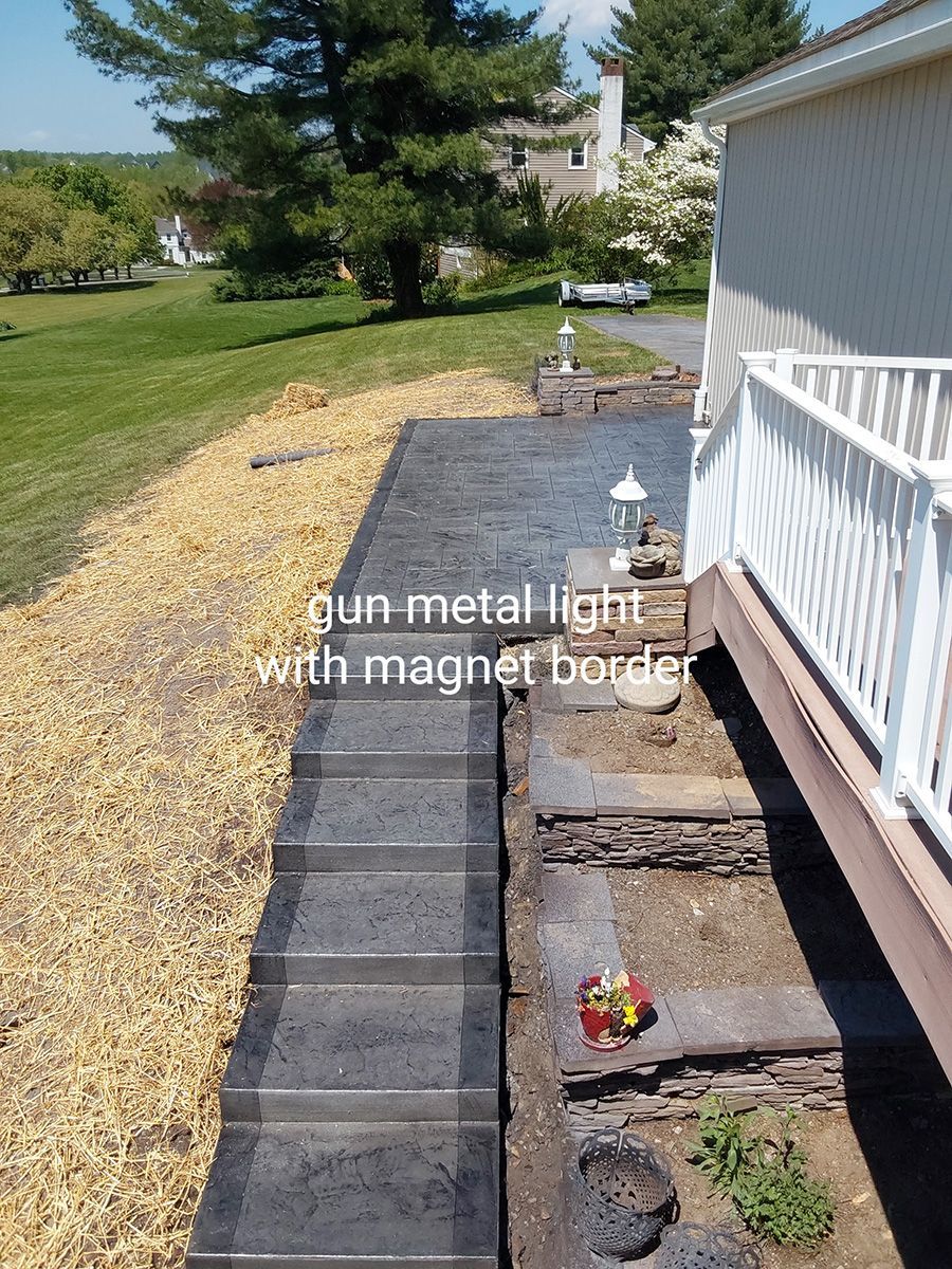 A picture of a walkway with a metal light and a magnet border