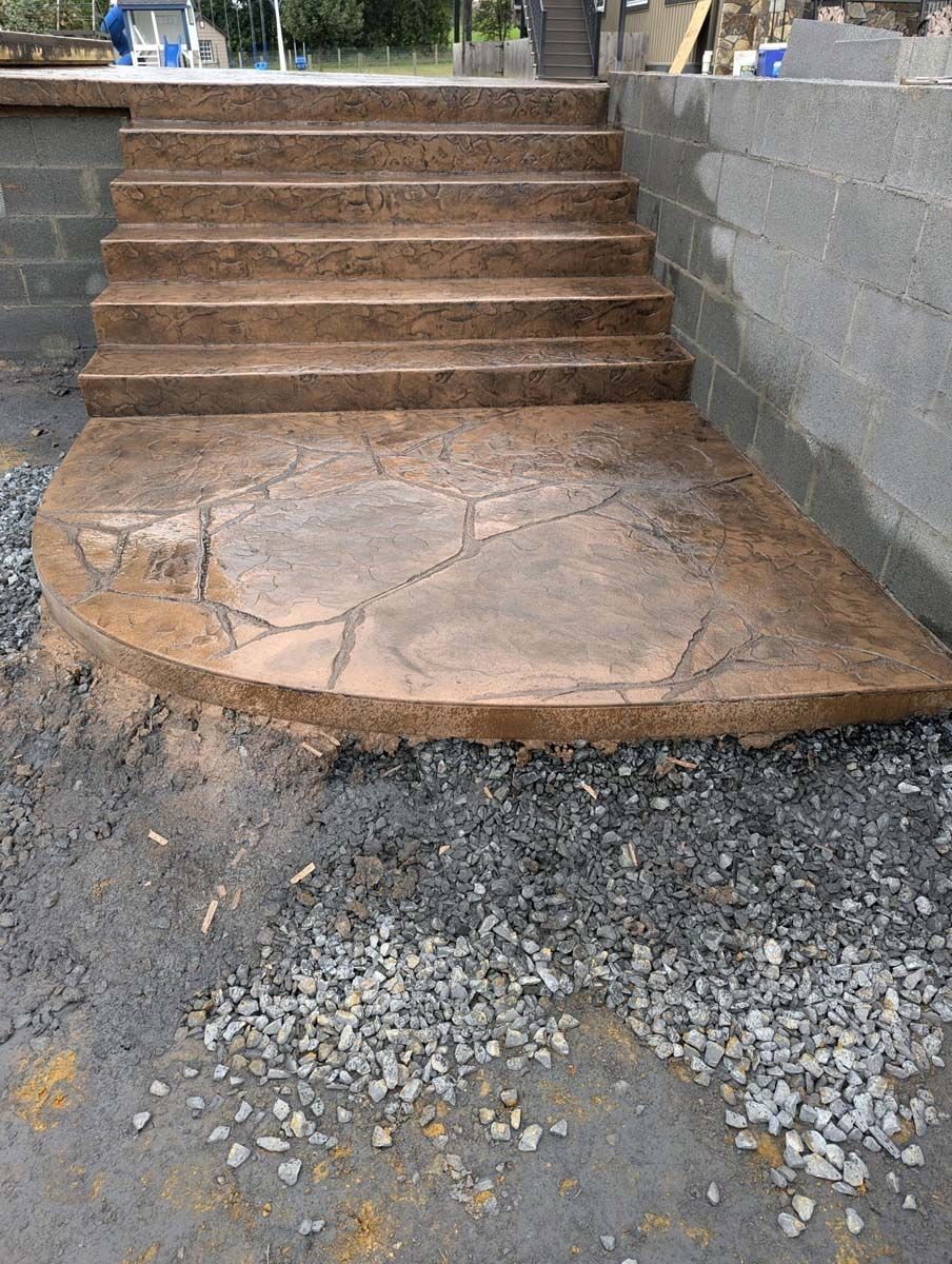 A set of concrete steps leading up to a brick wall.