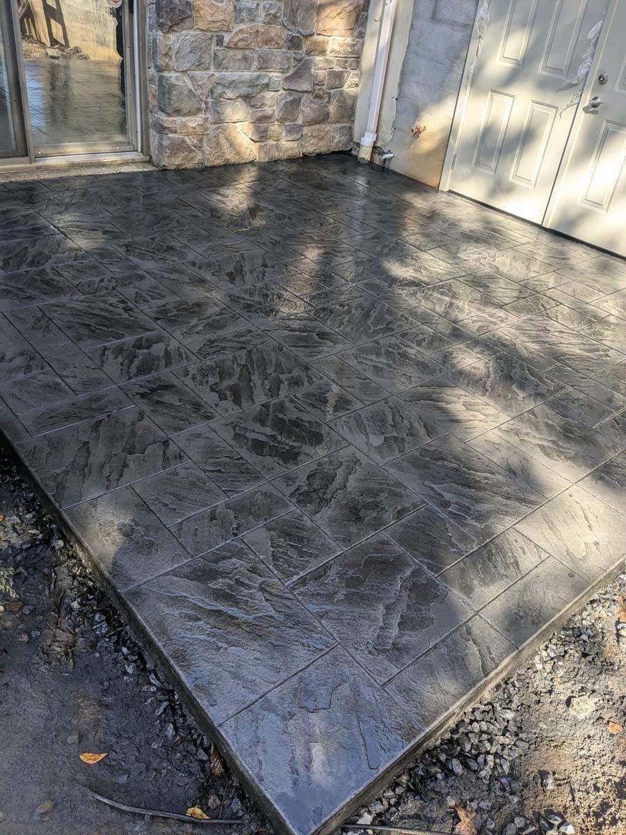 A concrete walkway with a stone wall in the background.