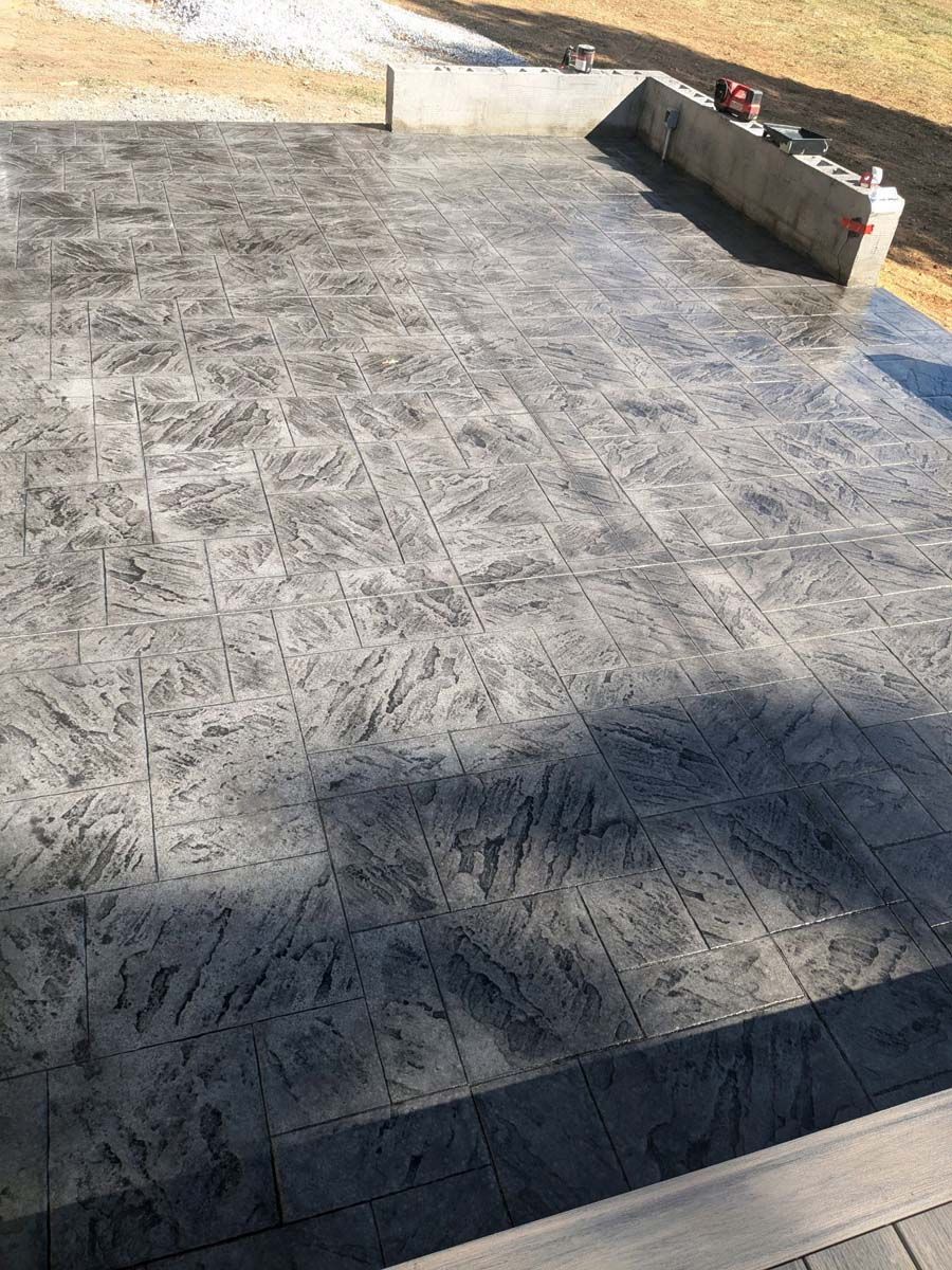 A concrete patio with a shadow of a person on it.