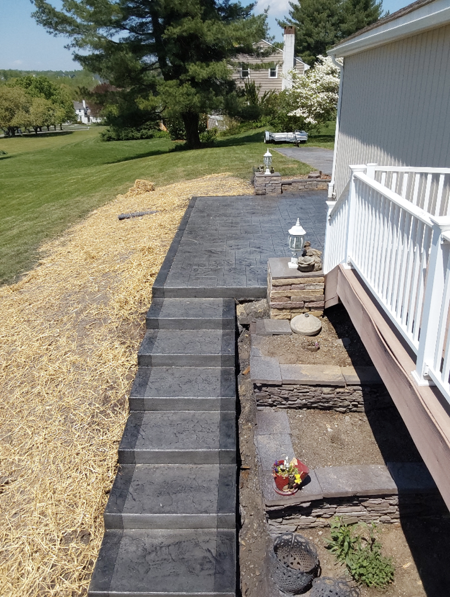 A walkway leading to a house with a white railing