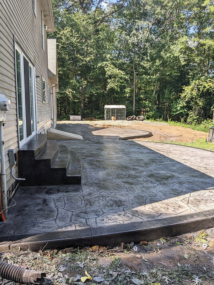 A concrete patio is being built in front of a house.