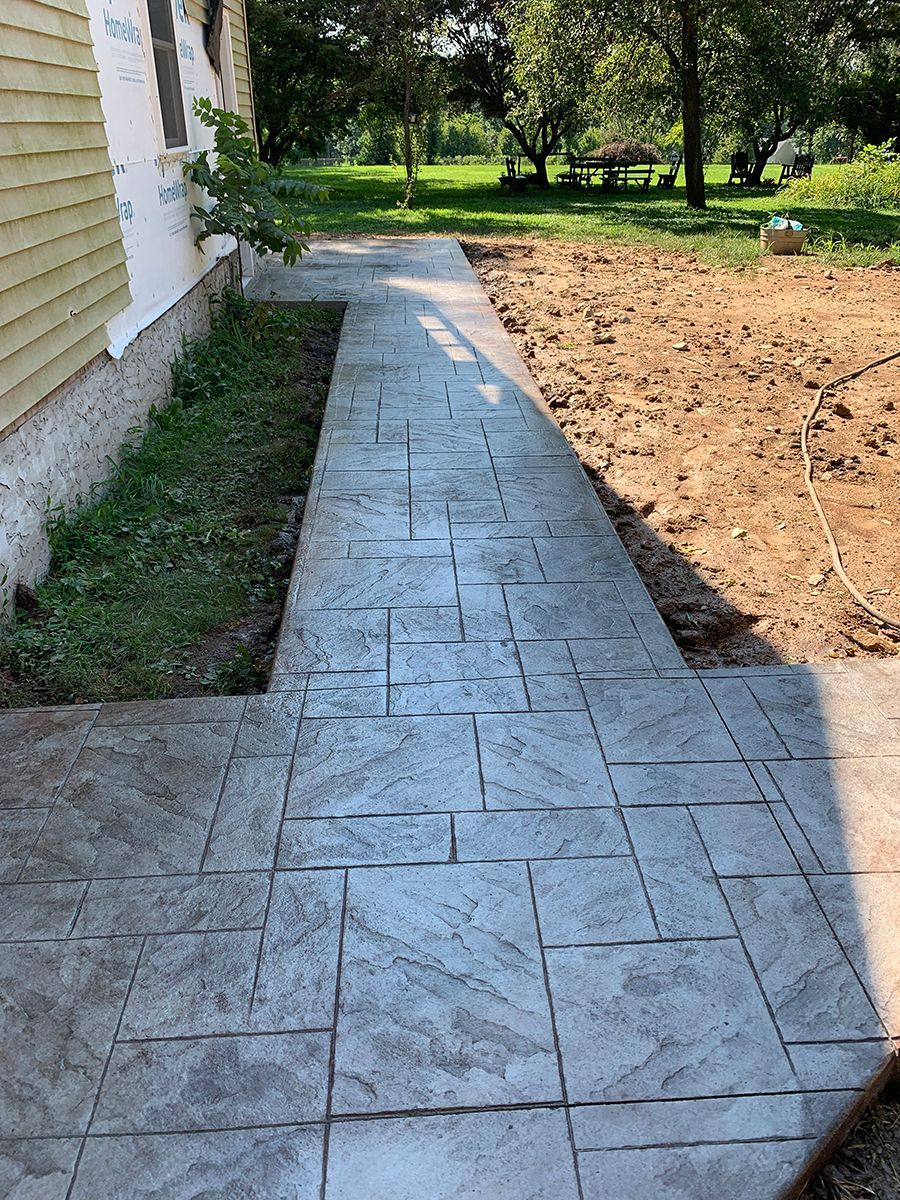 A concrete walkway is being built in front of a house.