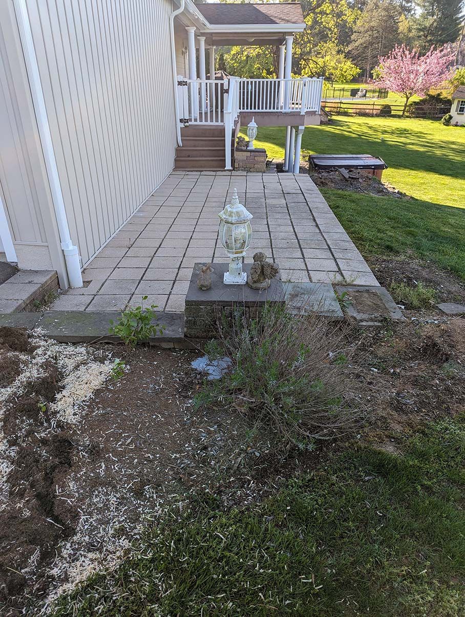 A brick walkway leading to a house with a statue in front of it.