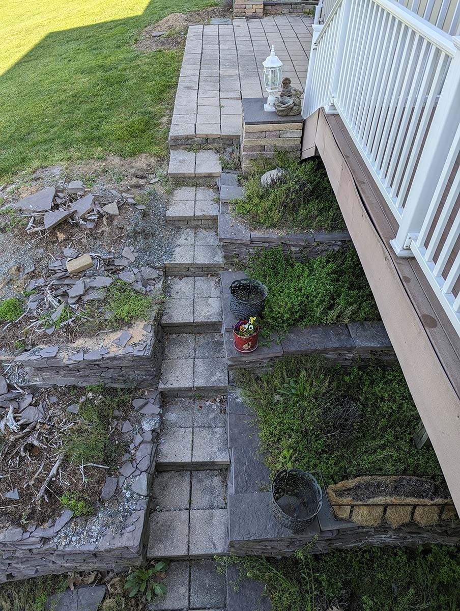 A set of stairs leading up to a deck in a backyard.