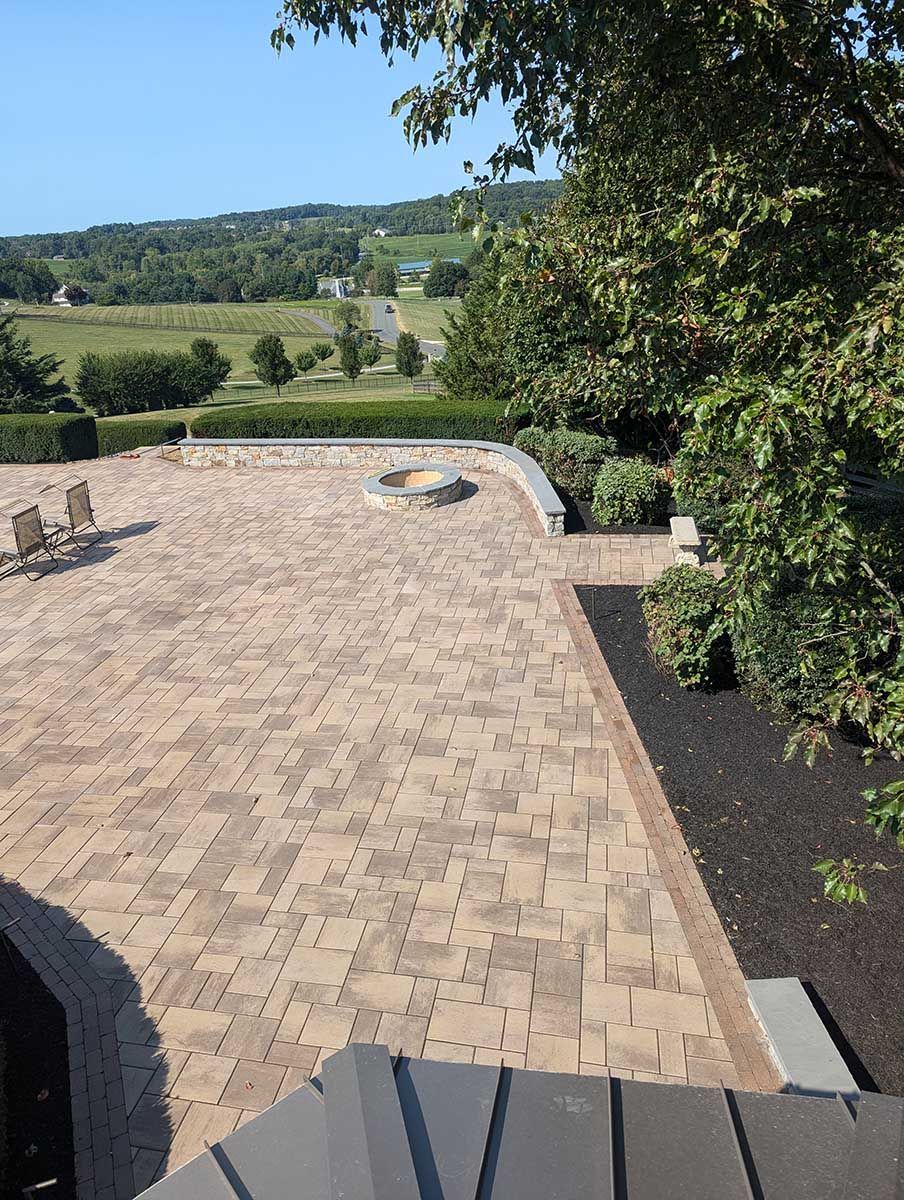 A brick patio with a fire pit in the middle of it