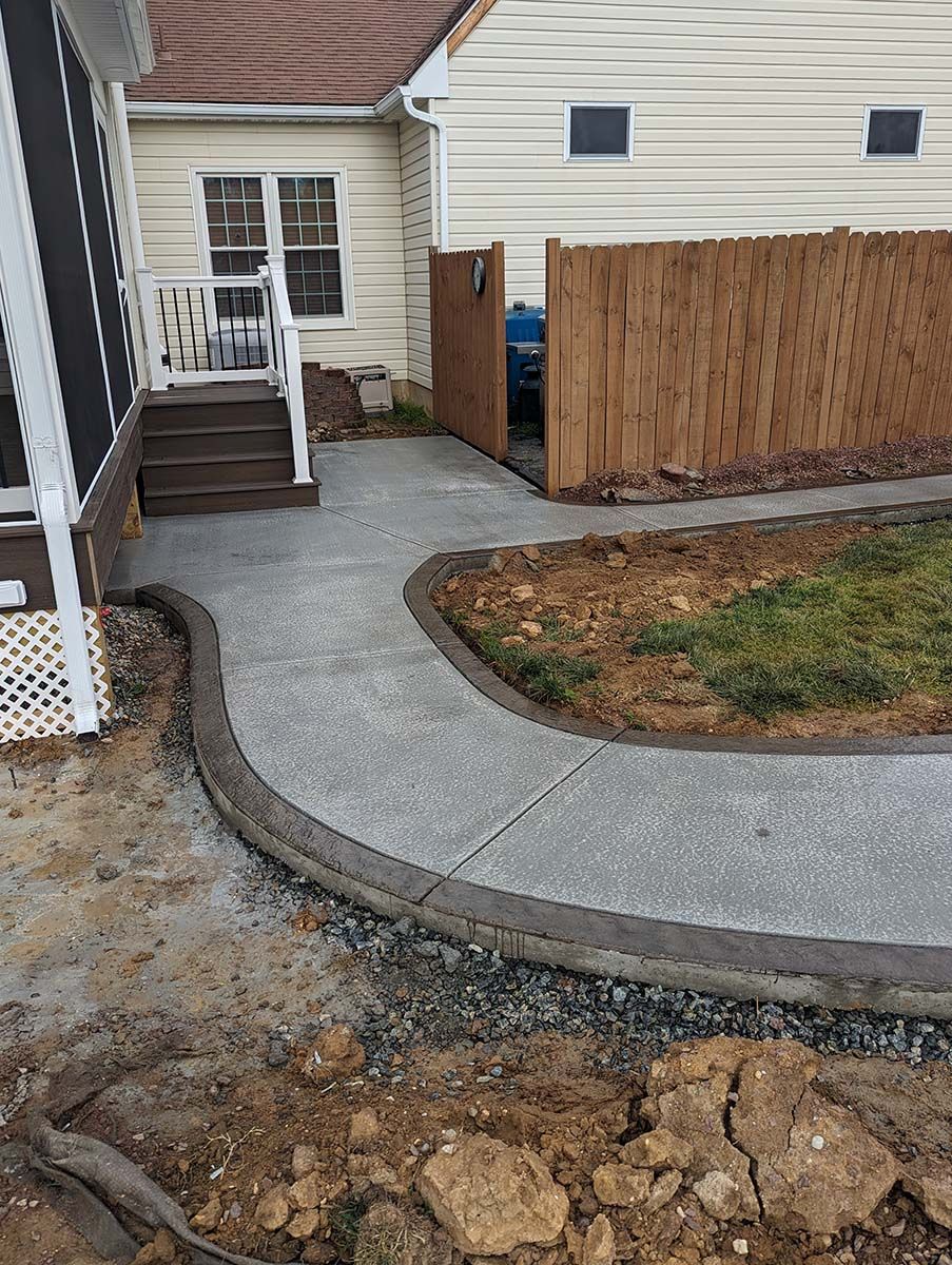 A concrete walkway is being built in front of a house.