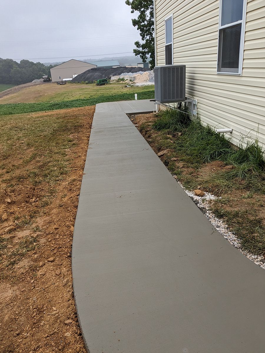 A concrete walkway is being built in front of a house.