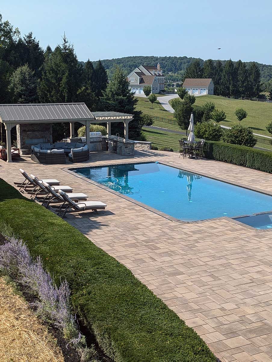 A large swimming pool with a gazebo in the background