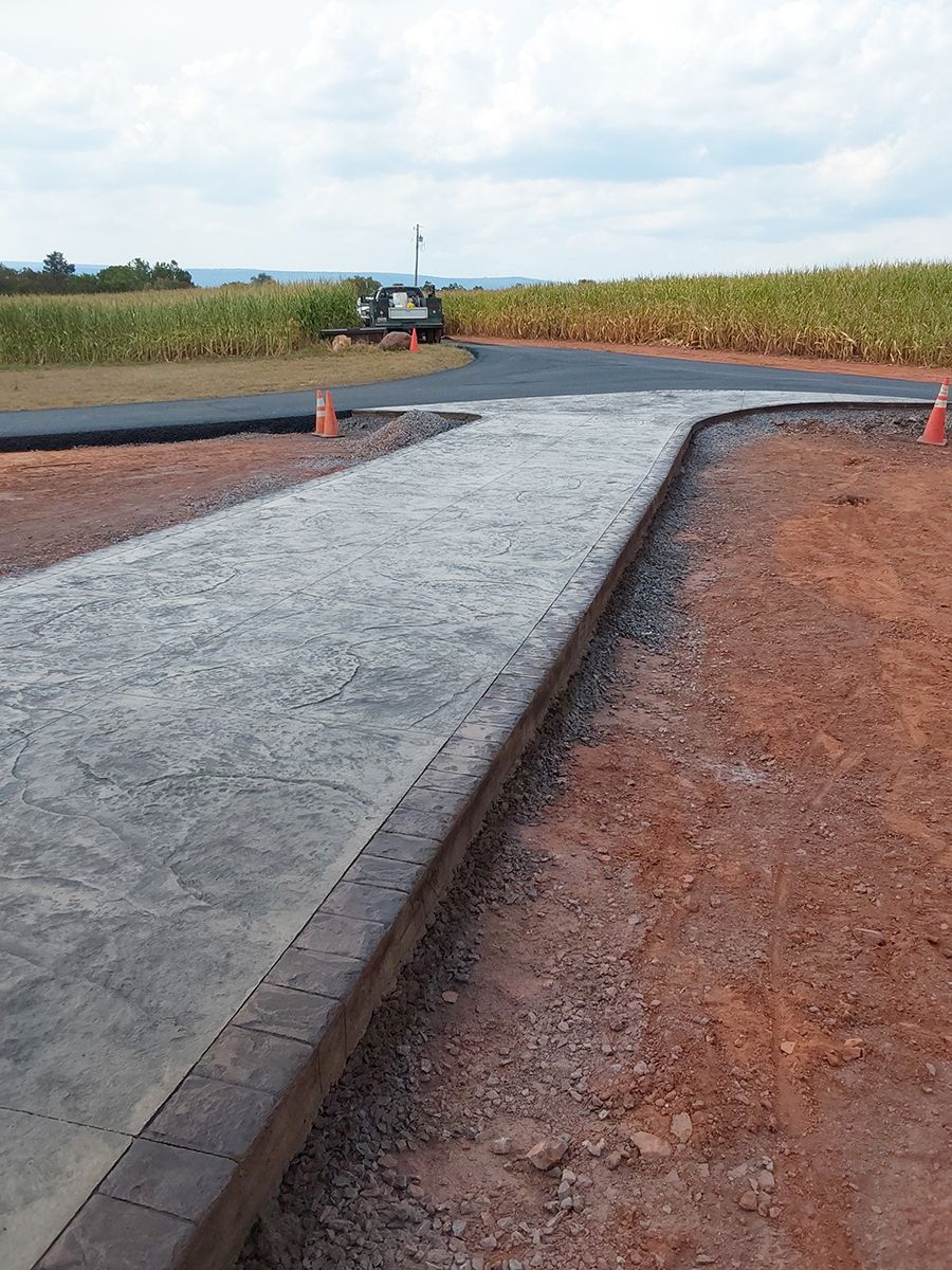 A concrete walkway is being built in the middle of a dirt field.